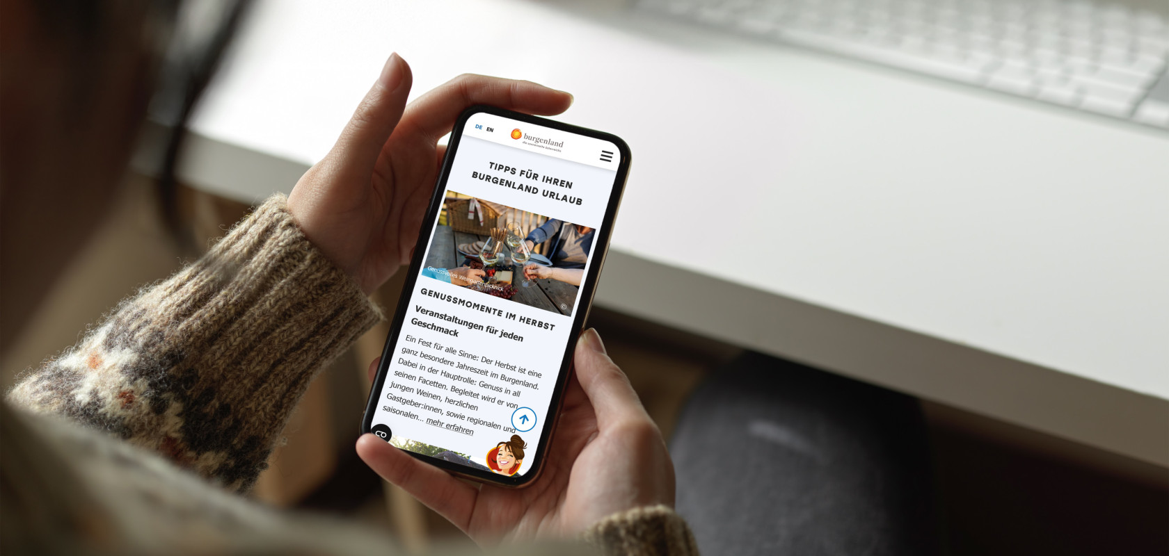 Person die ein Smartphone mit geöffneter Website von Burgenland Tourismus in beiden Händen hält